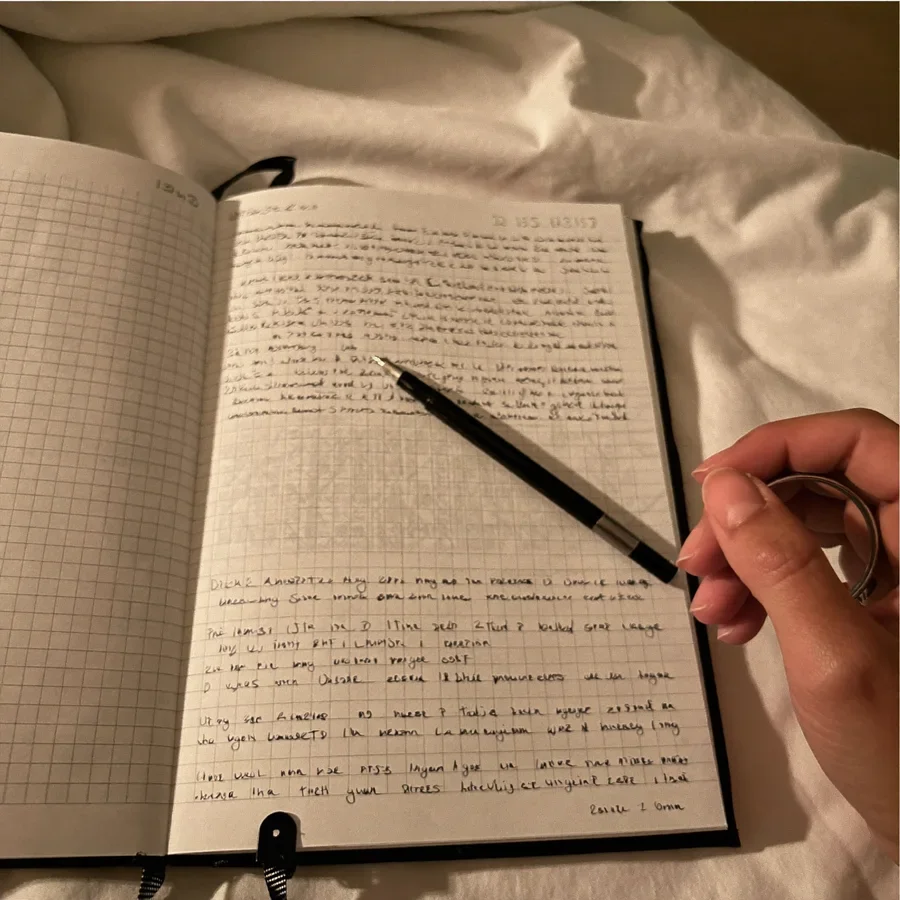 Diario abierto con notas escritas a mano sobre la cama