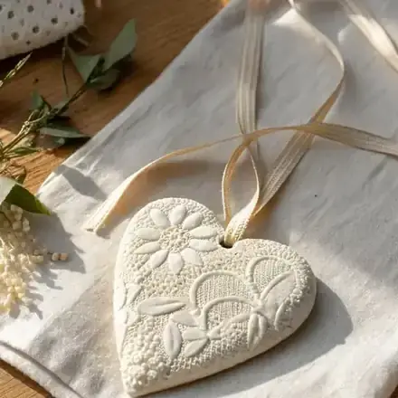 Corazón de arcilla que se seca al aire con textura de encaje y cinta