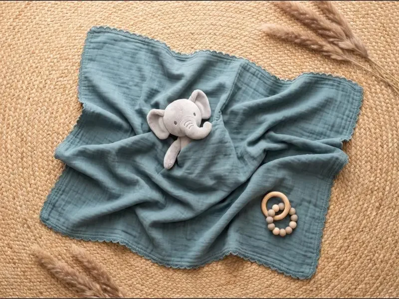 An elephant lovey blanket with a wooden teether